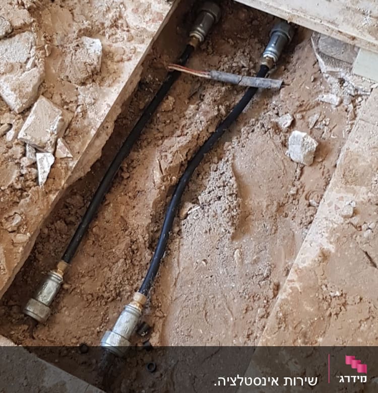 צינורות מים חשופים בתוך רצפה שבורה